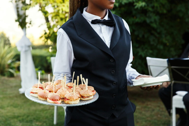 Waiter carries plate with tasty snacks